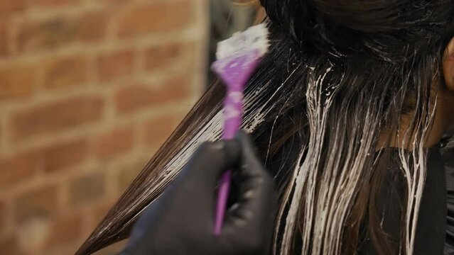 Hair highlighting procedure in a beauty salon - Woman getting her hair coloured. High quality 4k footage