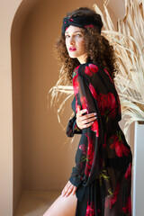 Beautiful woman with curly hair in summer clothes, tunic or pareo. 