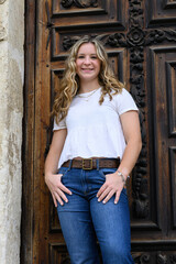 Fototapeta na wymiar Young pretty teenage girl posing in a historic setting for her high school graduation photos