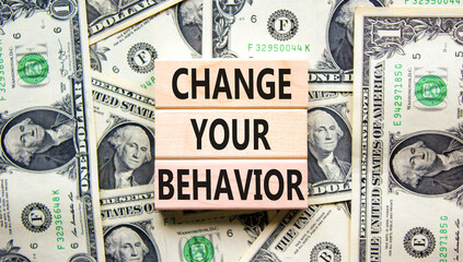 Motivation and Change your behavior symbol. Concept words Change your behavior on wooden block on a beautiful background from dollar bills. Business change your behavior concept. Copy space.