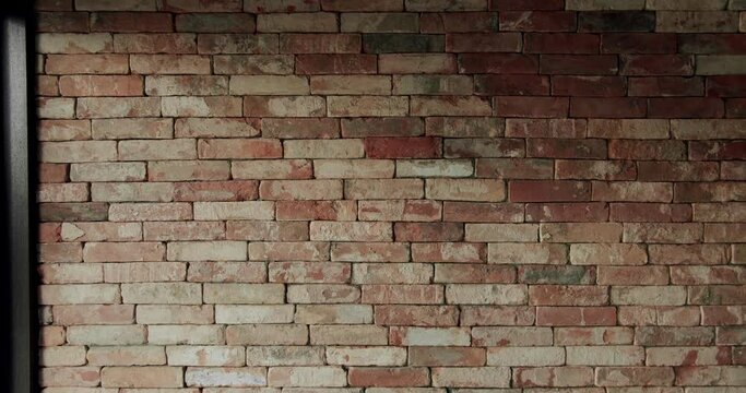 Old brick wall of brown color in a modern apartment, damaged masonry as abstract background composition. textured surface of stucco texture with holes and scuffs. brick room, interior texture