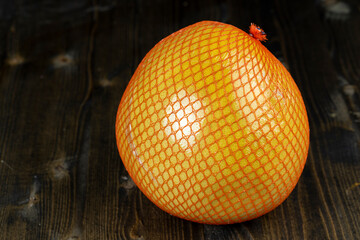 packed in a red mesh ripe yellow pomelo close-up