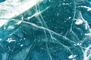The natural texture of winter ice with white bubbles and cracks on a frozen lake. Abstract...