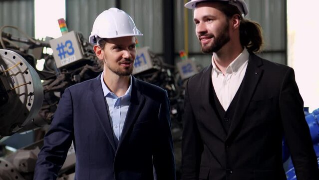 4k video Slow motion of 2 caucasian engineers or businessman handshake in factory workshop, Successful deal after negotiations. handshake of business people wearing hard hats in plant manufacture.