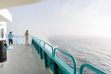 Man looking at the sea from the deck of a ferry