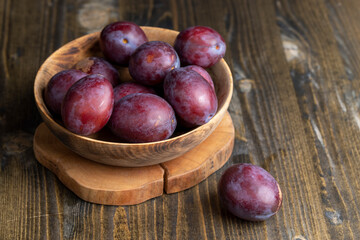 Ripe plums of dark color on the table