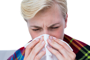 Sick blond woman blowing her nose
