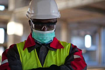 African american workman in mask stands at construction site