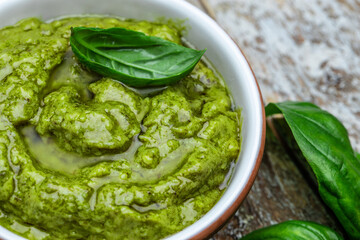 bowl with green pesto pine nuts, parmesan and garlic. Food recipe background. Close up