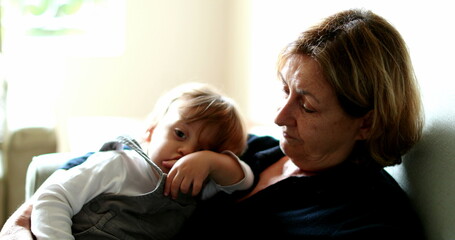 Grandmother with grandchild toddler in sofa