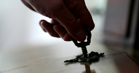 Close-up person removes key from furniture