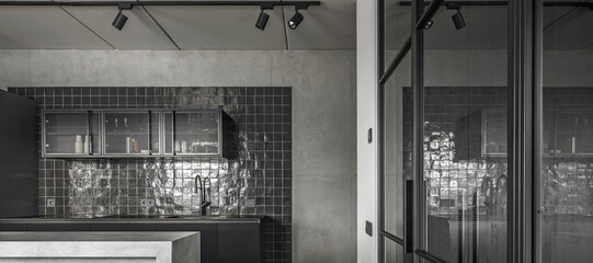 Small kitchen interior in grey and black colours, concrete wall design, glass sliding doors. Contemporary interior design aesthetics with concrete details