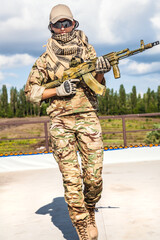 Girl with an assault rifle, strong determined, and capable woman. Holding the weapon with...