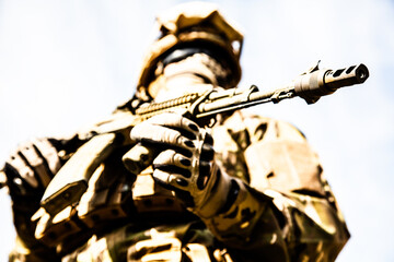 A low angle shot of a military soldier with weapons