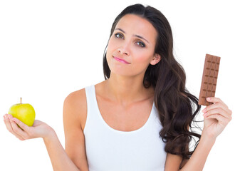 Pretty brunette deciding between apple and chocolate