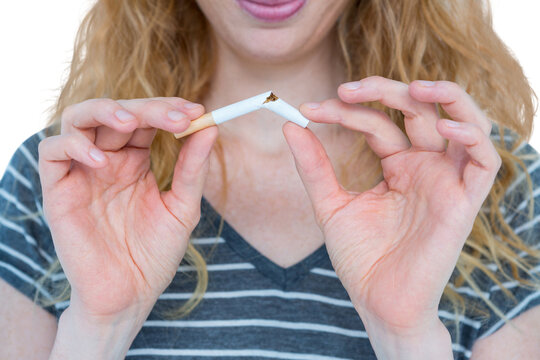 Woman snapping a cigarette over white background
