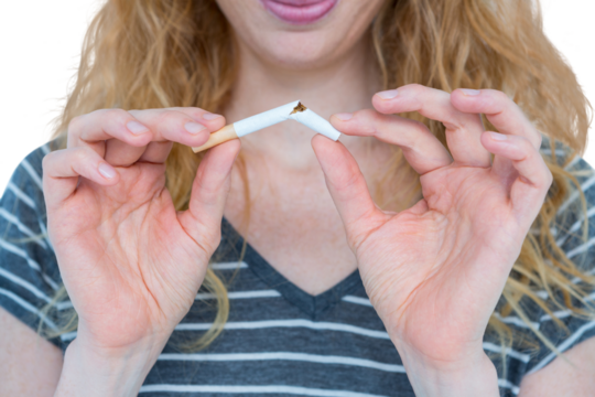 Woman snapping a cigarette over white background