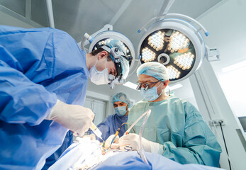 Team of surgeons in operating room. Medical specialists working in surgery room.