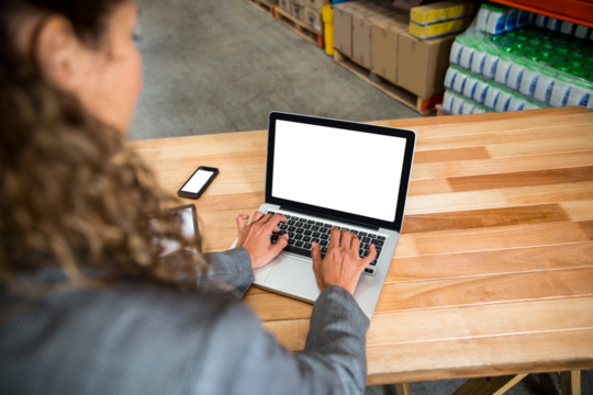 Businesswoman working on laptop at table - Powered by Adobe