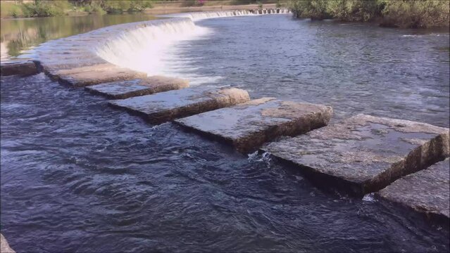 Small dam on a river with running water, small waterfall, barrage
