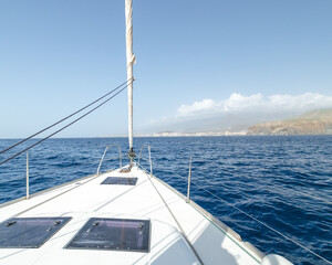 Fototapeta na wymiar Convés do iate branco navegando em mar aberto chegando a ilha Tenerife