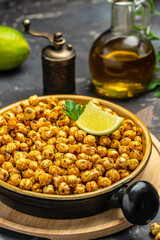 fried chickpeas on a dark background. Traditional Indian cuisine. Tasty vegetarian and vegan chickpea snack. vertical image. top view. place for text