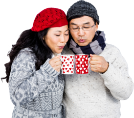 Happy couple blowing on cups