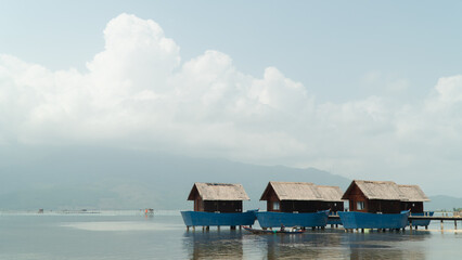 Blue fishing accommodation in the river against the background of the sky and clouds