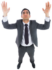Unsmiling businessman with arms raised