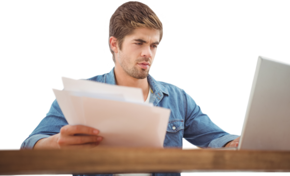 Hipster holding documents while working on laptop in office - Powered by Adobe