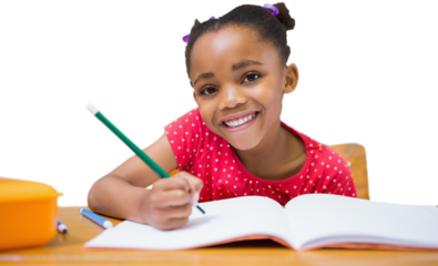 Cute pupils writing at desk in classroom