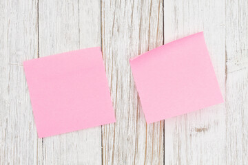 Two blank pink sticky note on weathered wood