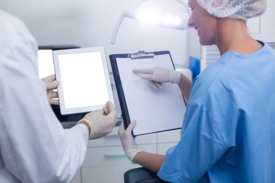 Dentist and dental assistant working on digital tablet - Powered by Adobe