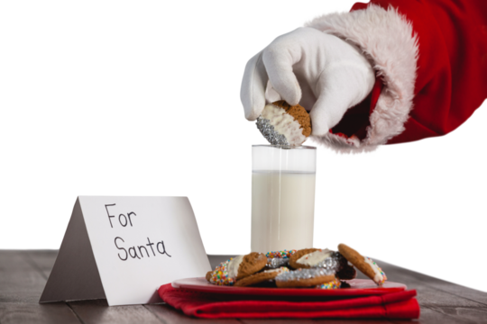 Cropped image of Santa Claus dipping cookies in glass of milk