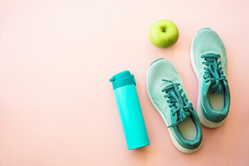 Workout and healthy lifestyle concept. Sneakers, green apple and bottle of water. Flat lay with copy space.