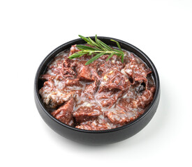 Canned beef or lamb stew in a black bowl with rosemary on a white isolated background.