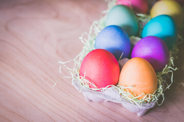 Fototapeta na wymiar Vibrant colorful easter eggs on a wooden table
