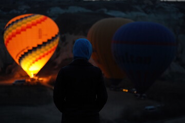 Obraz premium a man stands near the rising balloons at dawn