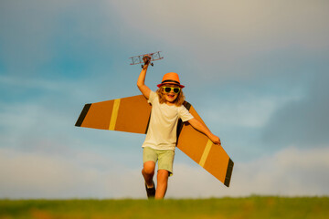 Child playing. Child boy toddler playing with toy airplane wings and dreaming future. The concept of child kindness and childhood. Children run with plane on field.