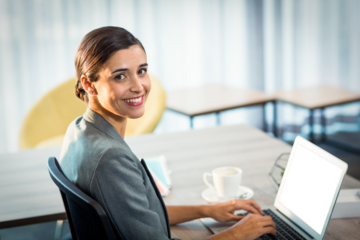Businesswoman smiling while using laptop