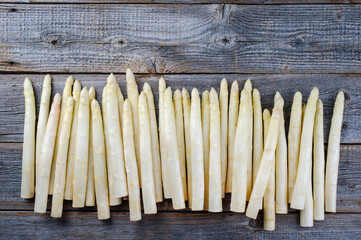 Roher weißer Spargel mit einer Reihe als Draufsicht mit Textfreiraum oben auf grauen gebleichten...