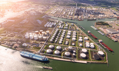 Aerial view of oil tankers and storage silo tanks at a petrochemical terminal port.
