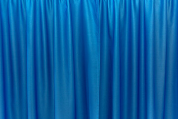 Closed draped bright blue silk curtain. Modern trends in interior decoration. Space for text.