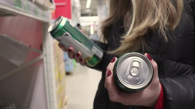 Girl customer chooses cans of beer