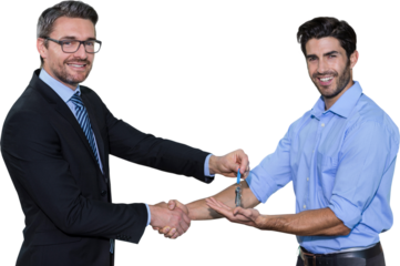 Smiling businessman giving keys and shaking hands