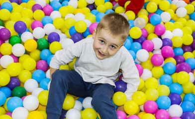 Fototapeta na wymiar cheerful blond boy having fun and playing in the game center, family recreation and entertainment