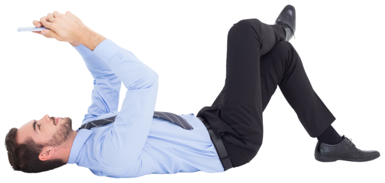 Cheerful businessman lying on floor using tablet