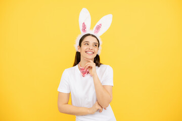 Obraz na płótnie Canvas Beautiful girl with bunny ears isolated on yellow background. Easter bunny woman looks fun.