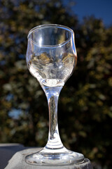 Outdoor macro photography of a small crystal glass on stone with natural background