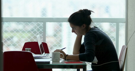 Woman taking brief from client in front of laptop computer working from home